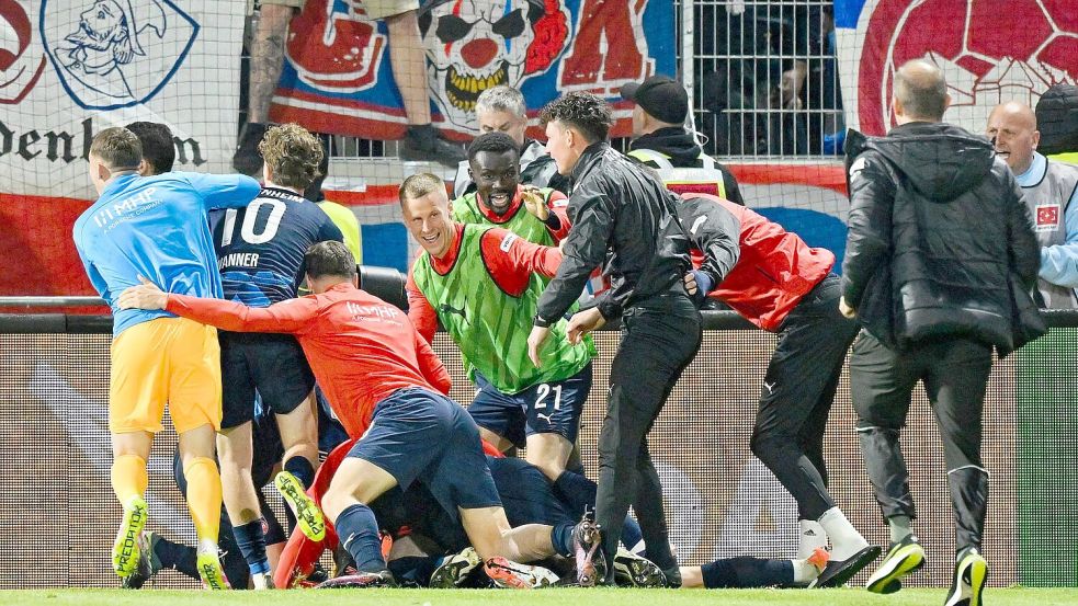 Die Heidenheimer Spieler feiern ausgelassen. Foto: Uwe Anspach/dpa