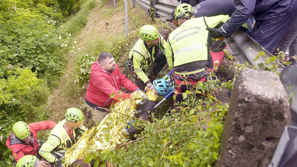 Der Italiener Alessio Martinelli wird nach seinem Sturz von Rettungskräften behandelt. Foto: Fabio Ferrari/LaPresse/AP/dpa
