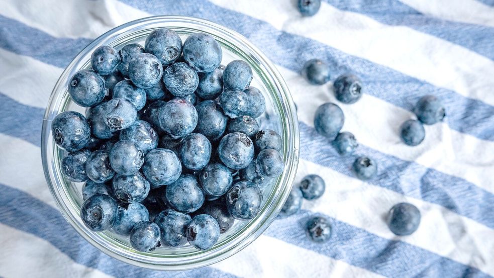 Beeren statt Chips oder Nüsschen: Heidelbeeren, auch Blaubeeren genannt, liegen auf einem Esstisch und werden gern gesnackt. Foto: Sina Schuldt/dpa
