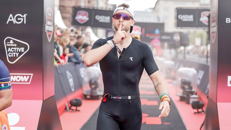 „Wir reden nicht, wir machen“: Lukas Siemers posiert nach seinem erfolgreich gemeisterten Ironman-Projekt im Ziel in Hamburg. Fotos: Sportfotograf.com