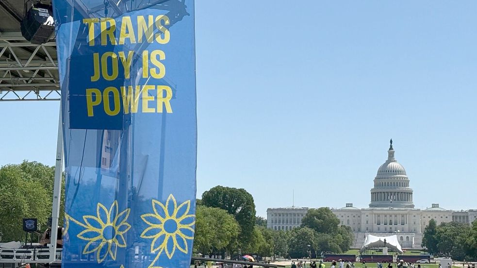 „Trans joy is power“ steht auf einem Banner an einer Bühne vor dem Kapitol am ersten Tag der Worldpride. Foto: Franziska Spiecker/dpa
