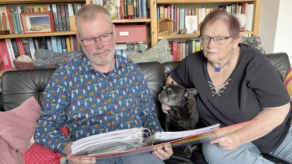 Dorothee Käufer und Edgar Lübking, die beiden selbstständigen Leiter der eigenständigen Erziehungsstelle Haus Bullerbü in Grotegaste, haben gegen einen Bescheid des Landkreises Leer Klage eingereicht. Sie schauen sich den Bescheid des Jugendamtes noch einmal an. Mit auf dem Sofa sitzt die Französische Bulldogge „Bella Donna“. Foto: Ammermann