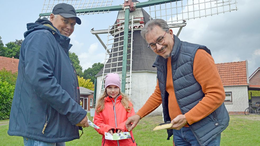 Die siebenjährige Amke Friedrichs und ihr Papa Peter erhielten in Tannenhausen von Matthias Klattenberg (rechts) ihren vierten und letzten Stempel für die Auricher Mühlen-Rallye. Foto: Aiko Recke