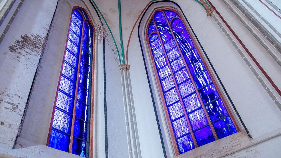 Zwei der vier von Günther Uecker gestalteten großen farbigen Glasfenster im Schweriner Dom. Foto: Jens Büttner/dpa