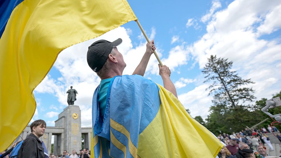 Menschen schwenken bei einer Solidaritätskundgebung in Berlin ukrainische Flaggen. Eine Städtepartnerschaft mit dem vom Krieg gebeutelten Land lehnt die Stadtpolitk ab. Foto: DPA