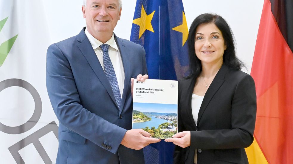 OECD-Generalsekretär Mathias Cormann übergibt den Wirtschaftsbericht an Bundeswirtschaftsministerin Katherina Reiche (CDU). Foto: dpa/Katharina Kausche