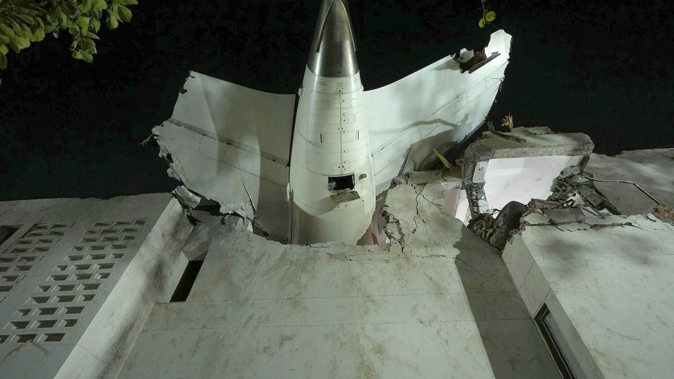 Das Heck des Flugzeugs steckt in einem Gebäude an der Absturzstelle in der nordwestindischen Stadt Ahmedabad im Bundesstaat Gujarat. (Foto aktuell) Foto: Ajit Solanki/AP/dpa