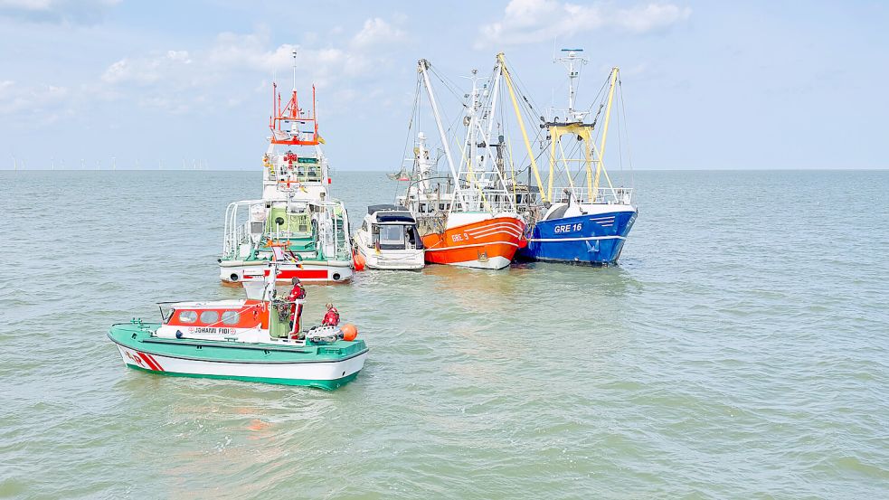 Das kleine Motorboot von Familie Selent zwischen den Fischkuttern und dem Seenotrettungskreuzer Hermann Rudolf Meyer. Foto: Die Seenotretter – DGzRS