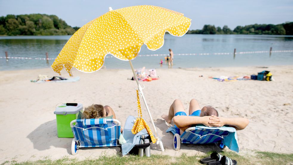 Sonnenschirm aufgespannt: Die sommerlichen Temperaturen dürften am Wochenende zahlreiche Badegäste an die Strände Niedersachsens ziehen. Foto: dpa/Hauke-Christian Dittrich