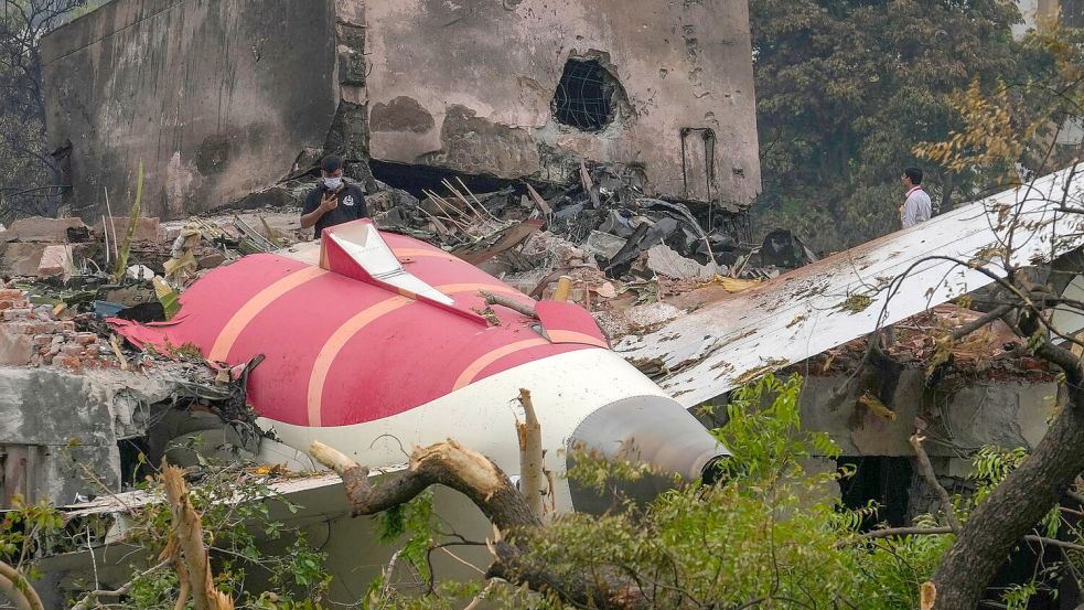 Teile eines Air India-Flugzeugs, das am Donnerstag abgestürzt ist, sind auf einem Gebäude in Ahmedabad, Indien, zu sehen. Foto: Rafiq Maqbool/AP/dpa