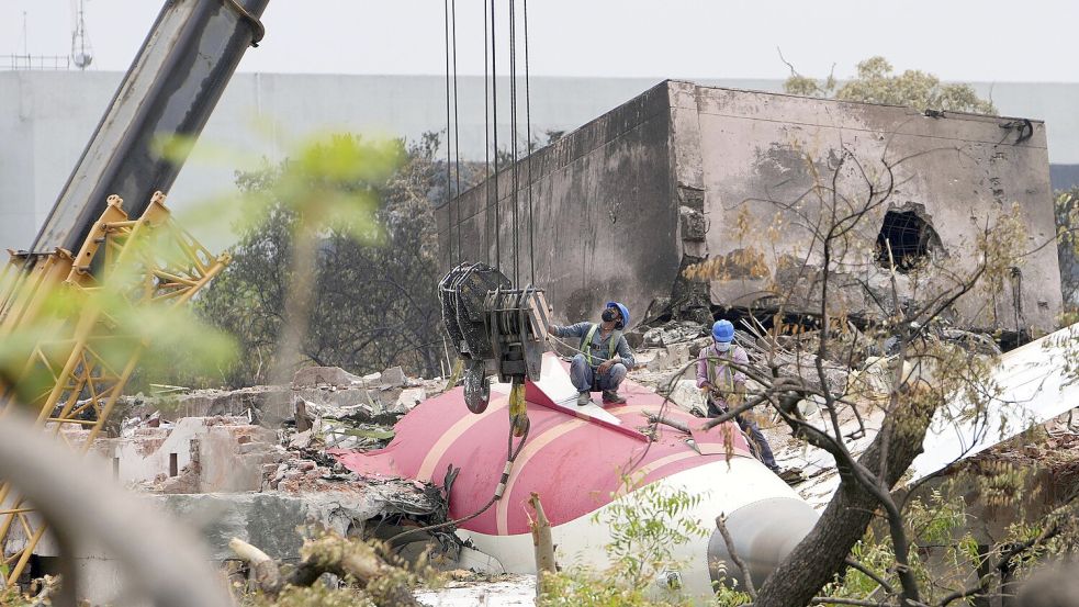 Eine Crew bereitet sich darauf vor, Teile des am Donnerstag abgestürzten Air India-Flugzeugs vom Dach eines Gebäudes in Ahmedabad, Indien, zu entfernen. Foto: dpa/AP/Ajit Solanki
