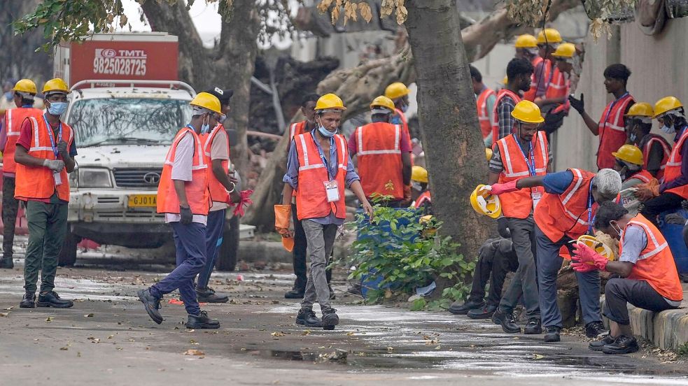 Arbeiter sind an der Absturzstelle im Einsatz. Foto: Rafiq Maqbool/AP/dpa