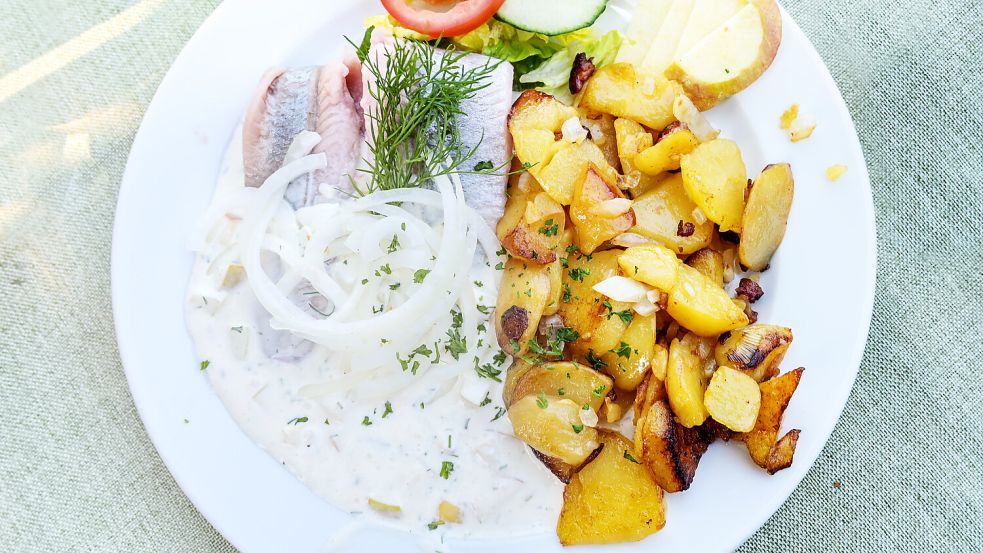 Passen gut zusammen: Matjes mit Zwiebeln und leckeren Bratkartoffeln. Foto: Maren Winter - stock.adobe.com