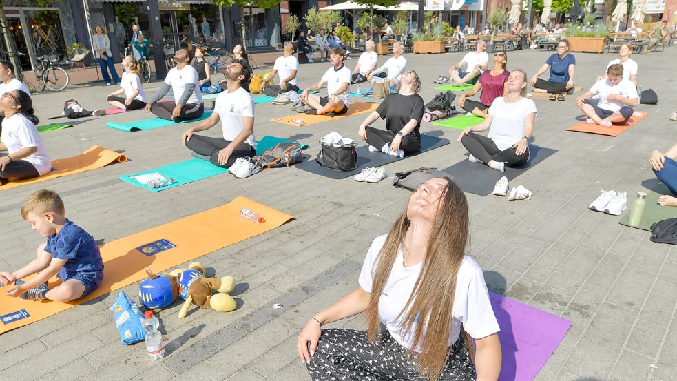 Der bei vielen Menschen oft steife Nacken wird gedehnt vor Beginn der Yoga-Einheit auf dem Neuen Markt. Fotos: Klaus Ortgies