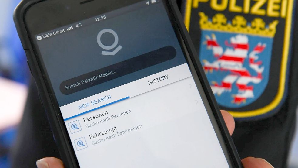 Ein Polizist in Hessen zeigt ein Dienst-Smartphone mit dem Logo der US-Firma Palantir. Foto: dpa