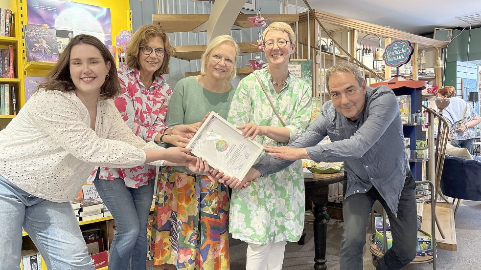 Volker Petri vom Landesverband Nord des Börsenvereins des Deutschen Buchhandels überreichte die Auszeichnung persönlich an das Team der Buchhandlung am Wall, hier vertreten von Lilian Musa, Susanne Kranz, Ellen Voigt und Katja-Zimmer Rapp (von links). Foto: Mieke Matthes