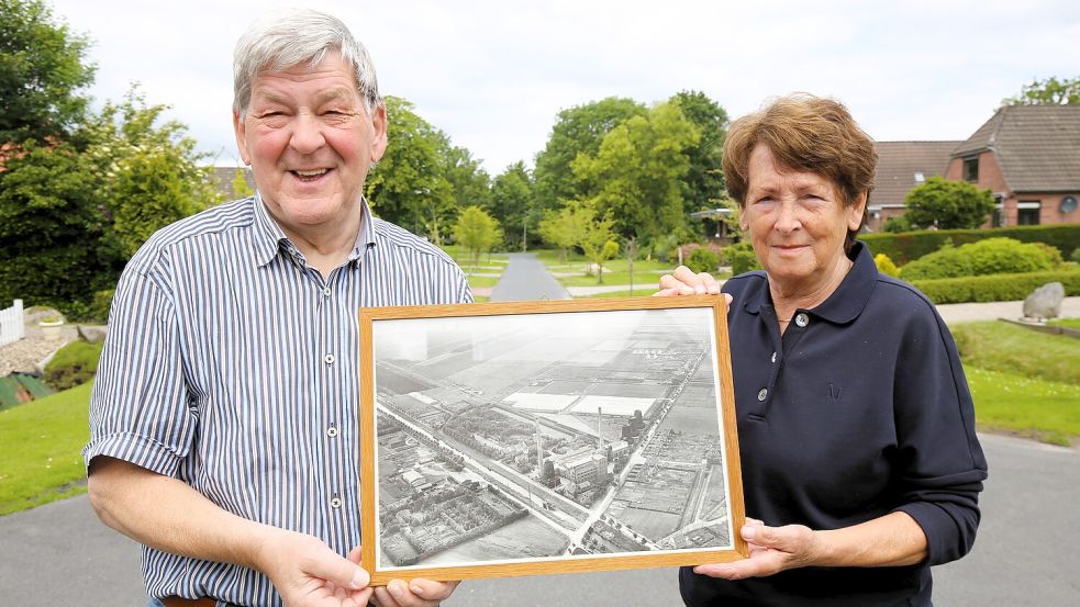 Wilfried und Erika Hedemann mit einem Luftbild Wiesmoors zu der Zeit, als das Kraftwerk und die Gärtnerei das Nachtjackenviertel entstehen ließen. Foto: Nicole Böning