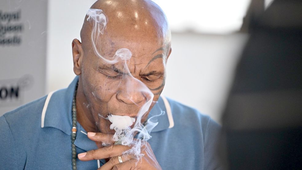 Mike Tyson, Boxer und Unternehmer, rauchte am Freitag an einem Stand der Cannabis-Messe Mary Jane einen Joint. Foto: Sebastian Gollnow/dpa
