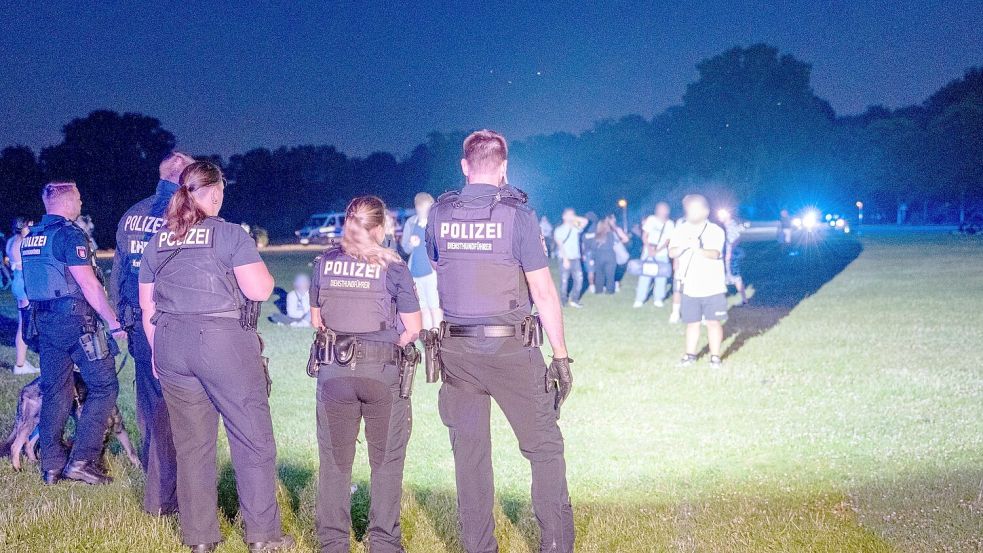 Einsatzkräfte der Polizei und Jugendliche stehen sich im Hamburger Stadtpark gegenüber. Foto: Rene Schröder/NEWS5/dpa