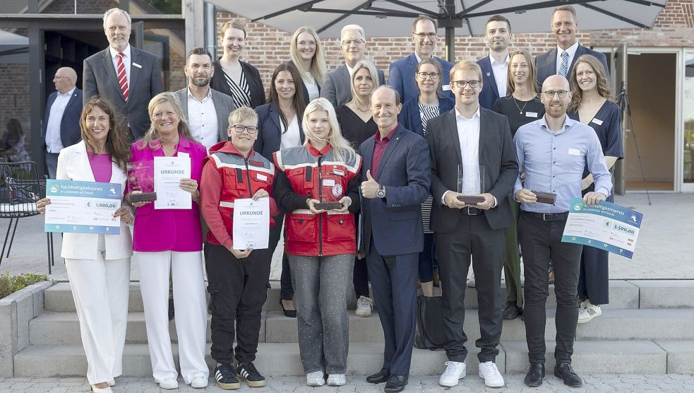 Das Foto zeigt (hinten, von links): Carsten Rinne und Jessica Zimmermann (beide Sparkasse Leer-Wittmund), Nele Fleßner und Mario Baumert (beide Raiffeisen-Volksbank eG), Holger Saß (Jade Hochschule), Steffen Wedemeyer (Landkreis Wittmund) und Holger Heymann (Landrat) sowie (Mitte, von links): Gerrit Pruss (Ewe Netz), Mira Sturm (Energiegenossenschaft für Wittmund), Sabrina Feldmann (Gemeinde Friedeburg), Katharina Glaum (Naturschutzhof Wittmunder Wald), Friederike Fischer (Landkreis Wittmund) und Elisa Bodenstab (Landkreis Wittmund). In der vorderen Reihe stehen die Preisträger (von links): Petra Ahrenholz und Kirsten Rottmann (beide Inselschule Langeoog), Mick Mellerke, Sofiia Fatieieva und Jurij Ils (alle Jugendwerk), Daniel Feddermann (bessergrün) und Fraederk Meppen (Kronsdobben). Fotos: privat