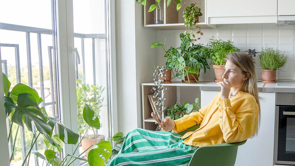 Welchen Gedanken sie wohl nachhängt? Eine nachdenkliche Frau schaut aus dem Fenster. Foto: IMAGO/Zoonar.com/Dmitrii Marchenko