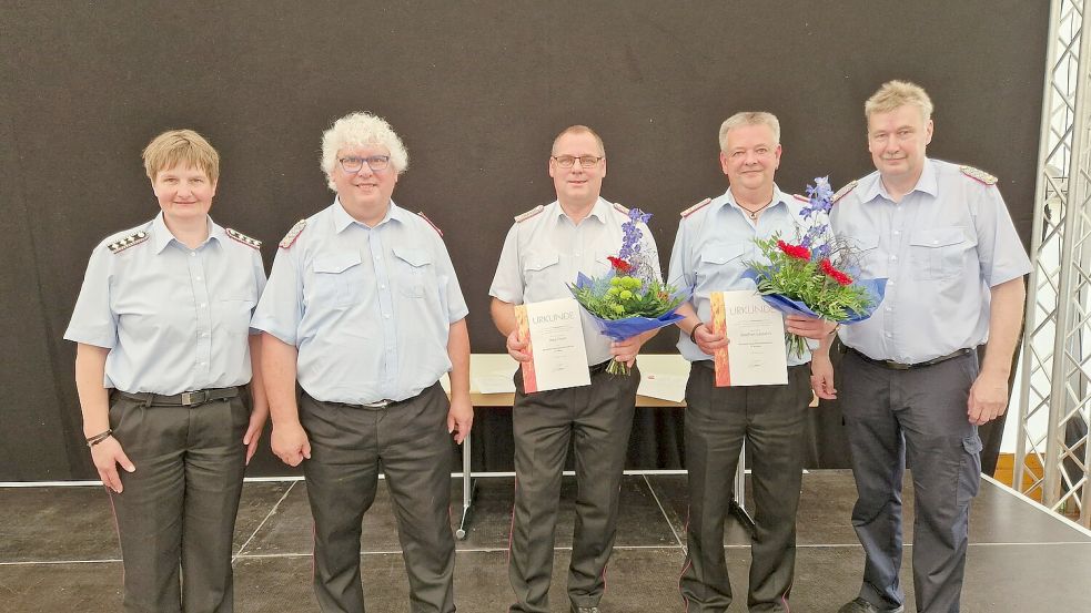 Die stellvertretende Verbandsvorsitzende Tanja de Freese (links), der Präsident des Feuerverbandes Ostfriesland (FVO) Friedhelm Tammen (2. von links) und der Kreisfeuerwehverbandsvorsitzende, Kreisbrandmeister Ernst Berends (rechts), zeichneten Jörg Fisser (3. von links) und Joachim Lassahn (2. von rechts) aus. Foto: Wiebke Rose