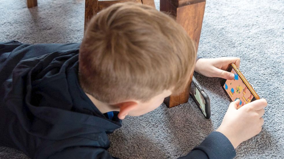 Kinder verlernen echte Kommunikation, wenn sie zu viel am Handy sind (Archivbild) Foto: Robert Michael/dpa-Zentralbild/dpa