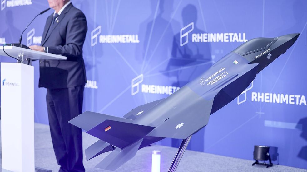 Ein Modell des F-35 auf der Bühne, auf der Konzernchef Papperger zu Mitarbeitern spricht. Foto: Oliver Berg/dpa