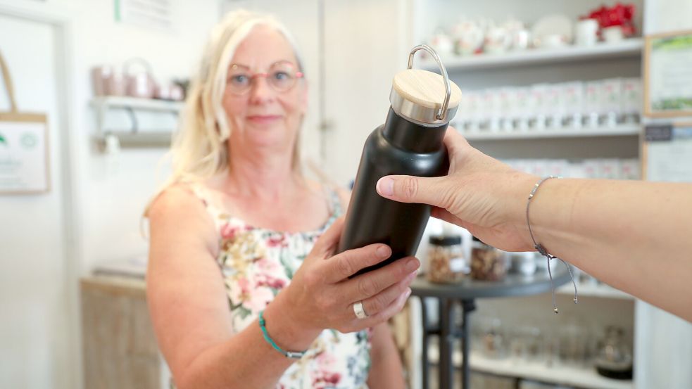 Beate Hansen von der Teemanufaktur in der Auricher Innenstadt füllt kostenlos Trinkwasserflaschen auf. Foto: Romuald Banik