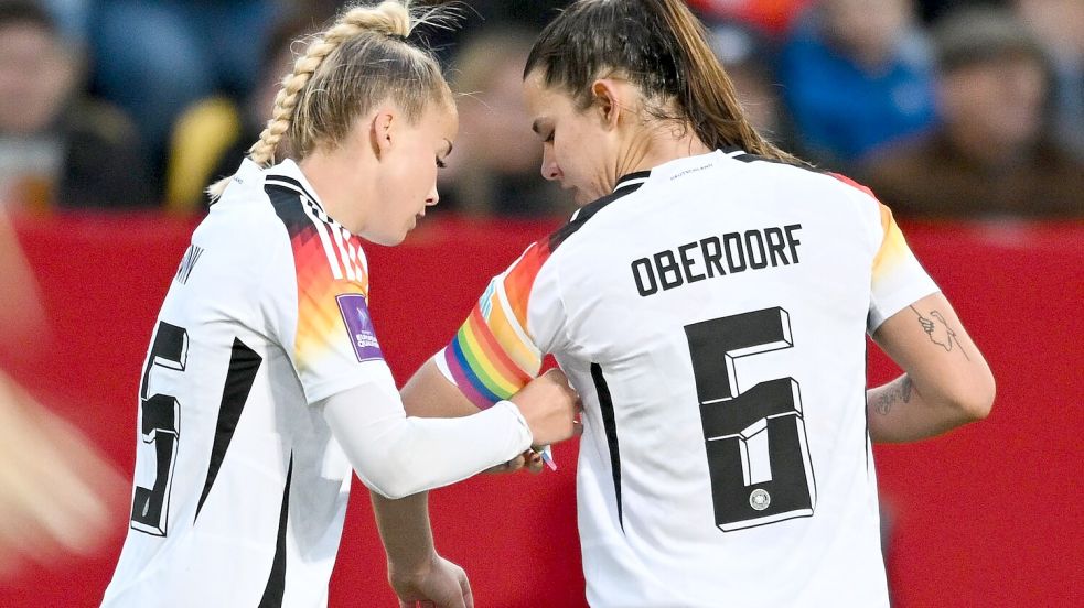 Giulia Gwinn (l.) trägt die Regenbogenbinde bei der EM Foto: Sebastian Christoph Gollnow/dpa
