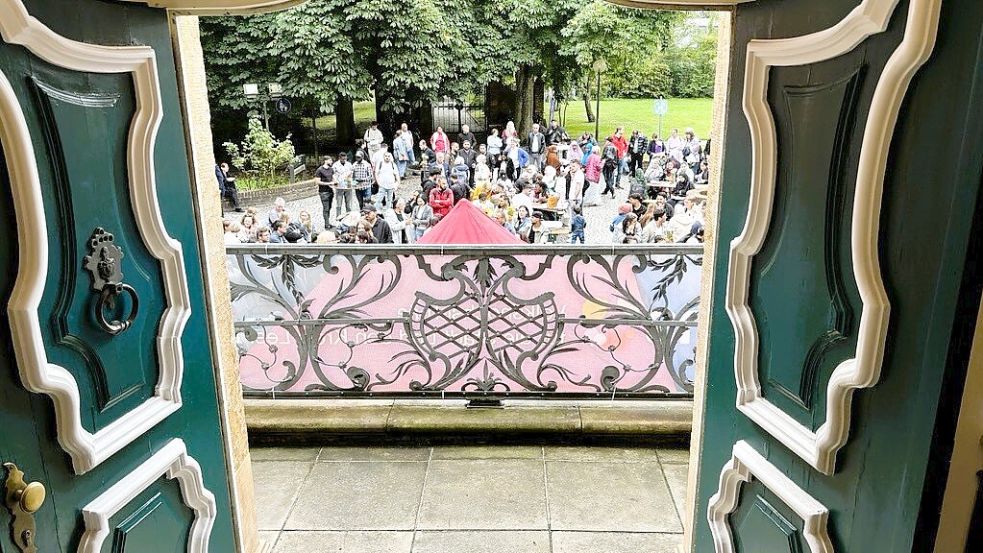 Der Innenhof füllt sich mit 200 Personen: Durch die Tür der Haneburg in Leer sieht man das Fest zu 20 Jahren Integrationskursen an der Volkshochschule. Foto: Vera Vogt