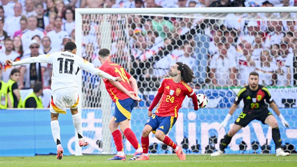 Jamal Musiala schießt - und Spaniens Marc Cucurella wehrt den Ball im EM-Viertelfinale mit dem abgespreizten Arm ab. Foto: Tom Weller/dpa