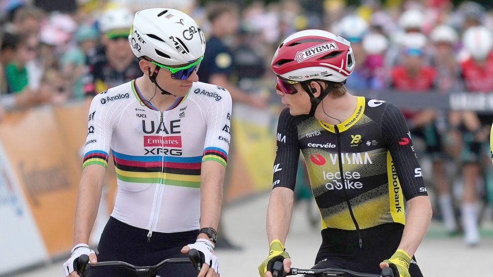 Die Top-Stars und Konkurrenten Tadej Pogacar (L) und Jonas Vingegaard unterhalten sich vor dem Start der 112. Tour de France. Foto: Mosa’ab Elshamy/AP/dpa