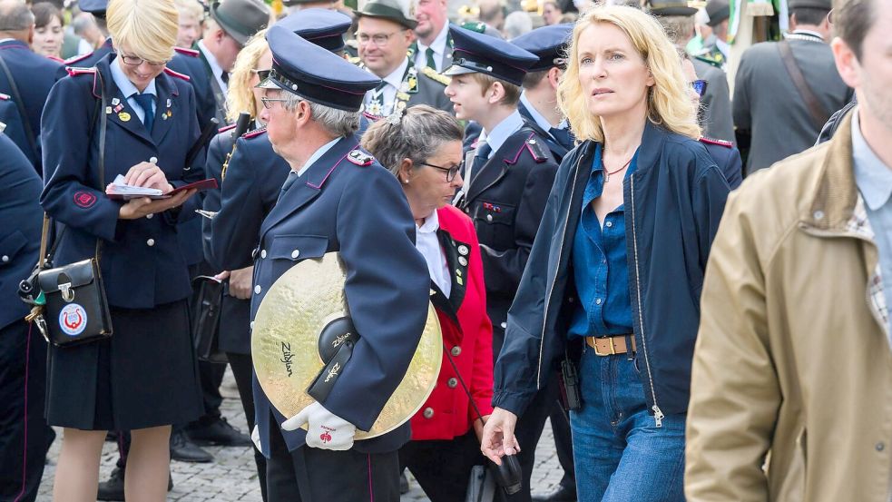 Die Schauspielerin Maria Furtwängler steht bei Dreharbeiten für einen neuen fiktiven „Tatort“ inmitten des realen Schützenausmarsches am Neuen Rathaus. Foto: Julian Stratenschulte/dpa