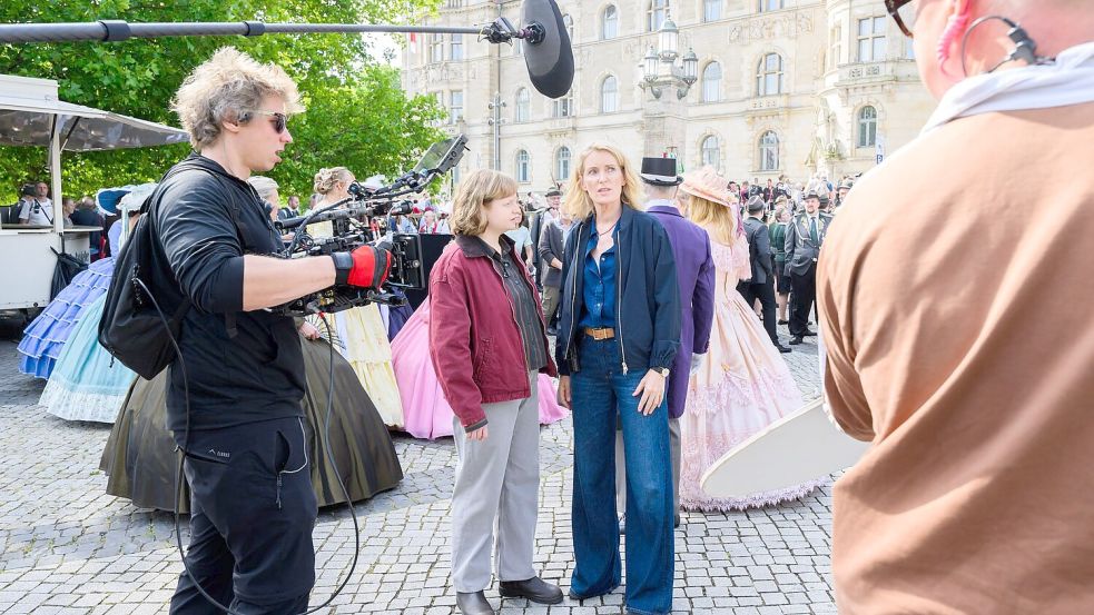 Die Schauspielerinnen Luise von Stein (l) und Maria Furtwängler stehen bei Dreharbeiten für einen neuen „Tatort“ inmitten des realen Schützenausmarsches am Neuen Rathaus. Foto: Julian Stratenschulte/dpa