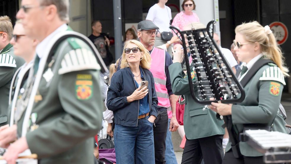 Die Schauspielerin Maria Furtwängler (M) steht bei einer Drehpause für einen neuen „Tatort“ inmitten des realen Schützenausmarsches. Foto: Julian Stratenschulte/dpa
