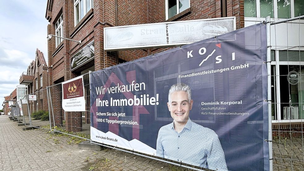Der ehemalige Eigentümer Dominik Korporal wirbt am Bauzaun des seit dem Brand leer stehenden Gebäudes für sein Unternehmen. Foto: Nicole Böning