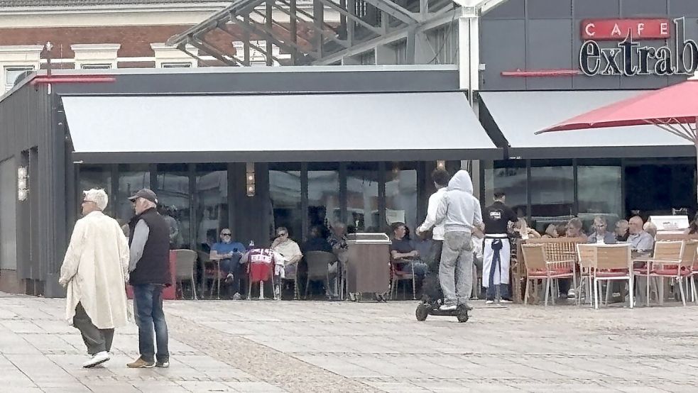 Zwei junge Männer fahren zu zweit auf einem E-Scooter über den Auricher Marktplatz. Viele Facebook-Nutzer beschweren sich über ein solches Verhalten. Foto: Eva van Loh