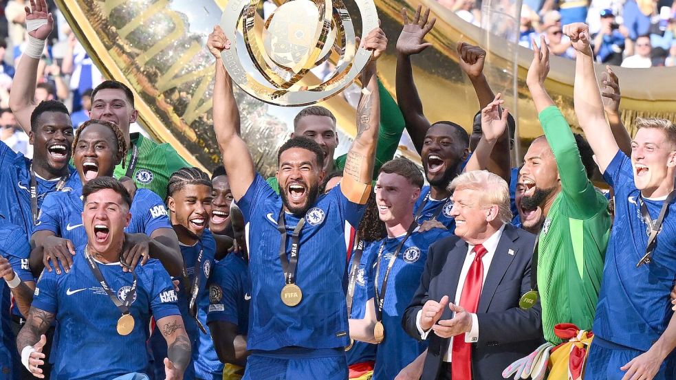 US-Präsident Donald Trump bleibt einfach bei den Chelsea-Spielern auf dem Siegerpodest und applaudiert ihnen. Foto: Sven Hoppe/dpa