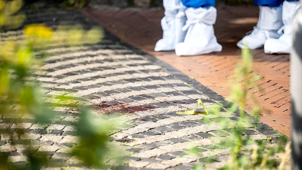 Die Spurensicherung untersucht Blut auf der Fahrbahn. Foto: Sina Schuldt/dpa