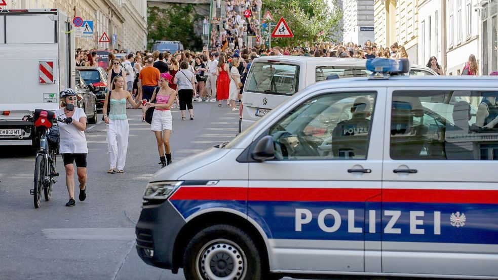Ein Polizeiauto steht in der Nähe von versammelten „Swifties“, nachdem im Sommer 2024 Konzerte abgesagt wurden aus Angst vor einem Terroranschlag. (Archivbild) Foto: Heinz-Peter Bader/AP/dpa