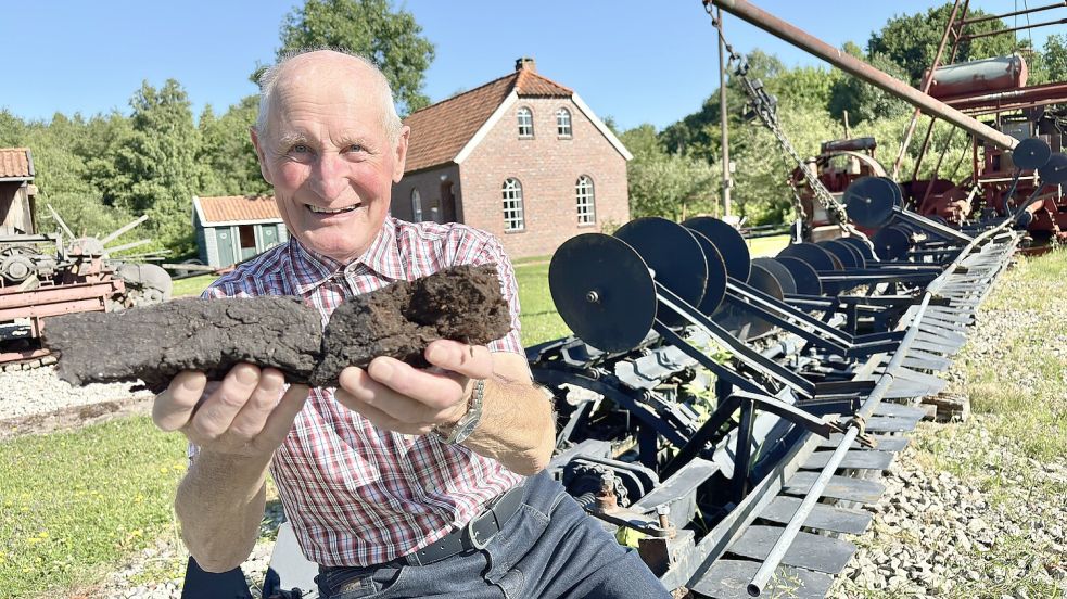 Jürgen Kleen ist ein wandelndes Lexikon für die Geschichte des Torf- und Siedlungsmuseums. In der Hand hält er den Brennstoff, der Ostfriesland den ersten Strom aus Wiesmoor brachte. Foto: Klaus Ortgies