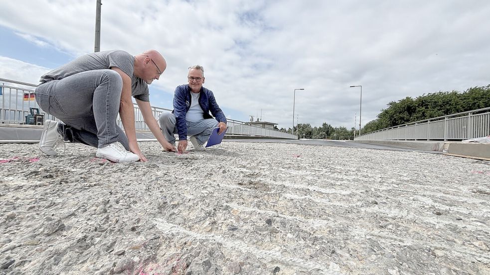 Projektleiter Frank Lakatsch (rechts) und Stadtwerke-Sprecher Edgar Behrendt schauen sich die Stahlbewehrung im Fahrbahnbeton an. Foto: Jonas Bothe