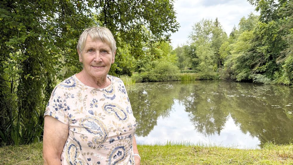 Herta Kruse aus Wiesmoor auf der nicht nutzbaren Fläche hinter ihrem Haus. Obwohl hier nicht gebaut werden darf, gilt sie als Bauland und wird auch so besteuert. Foto: Nicole Böning