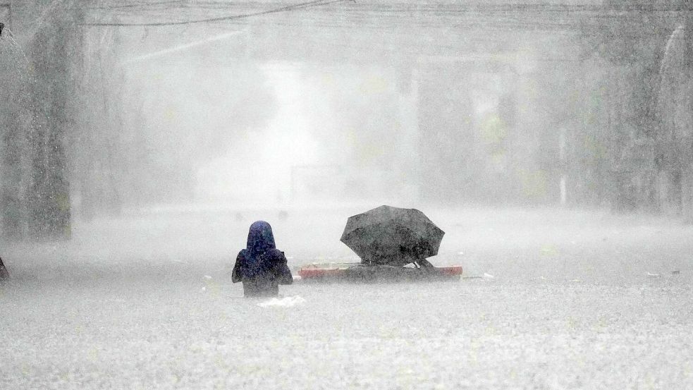 Die Menschen mussten durch brusttiefes Wasser waten. Foto: Aaron Favila/AP/dpa