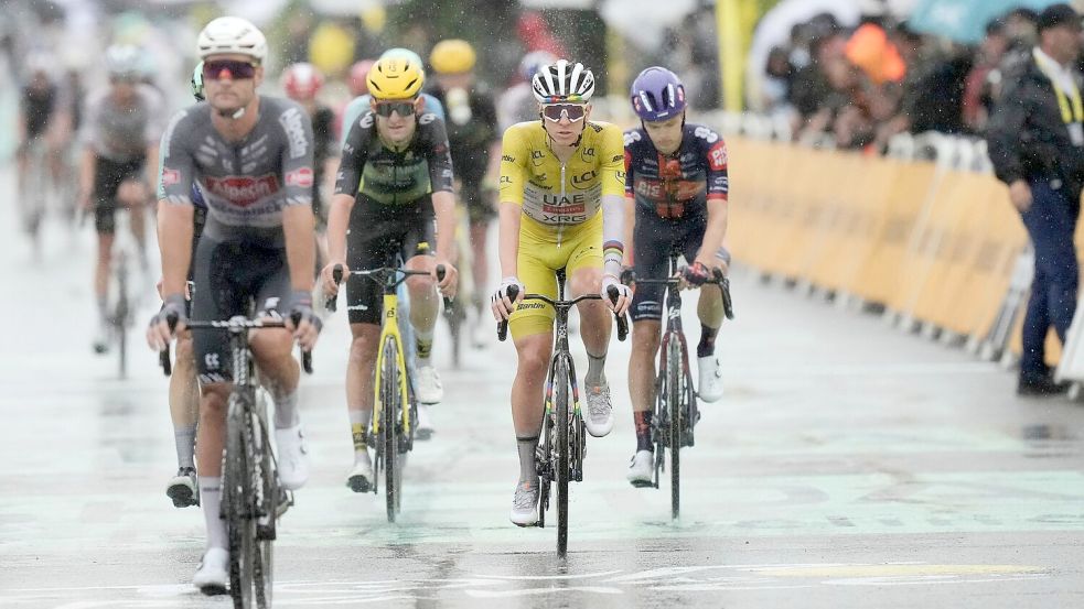 Der Tour-Führende Tadej Pogacar kommt bei Regen ins Ziel. Foto: Thibault Camus/AP/dpa
