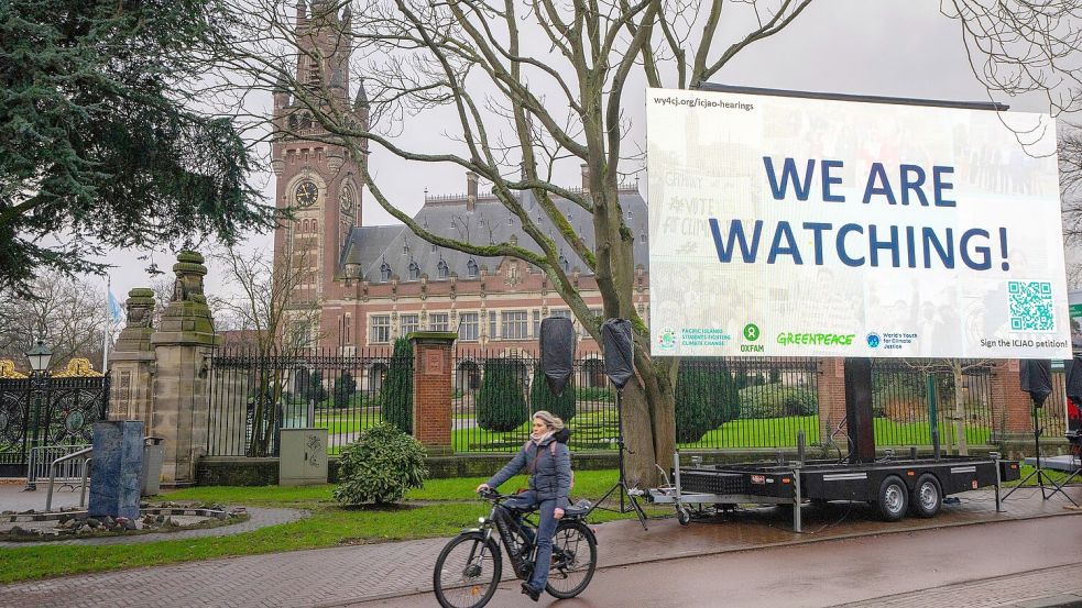 „We are Watching!“ ist auf einem Plakat vor dem Internationalen Gerichtshof zu lesen: Das höchste UN-Gericht hat sich mit Klimaschutz befasst. (Archivbild) Foto: Peter Dejong/AP/dpa