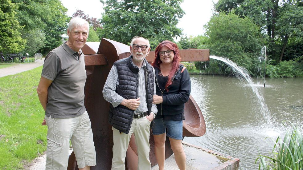 Leo Wübbena (Mitte) vor einer seiner bereits in den Wittmunder Schlosspark umgezogenen Stahlplastiken. An seiner Seite: Dirk Gronewold und Gritje Peters vom Heimatverein. Foto: Imke Oltmanns