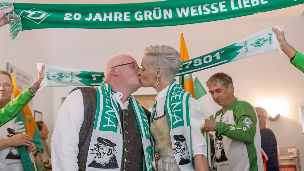 Im Spalier der Werder-Freunde gaben sich die frisch getrauten Andre und Martina Krause ein Küsschen als Ehepaar. Foto: Nordphoto