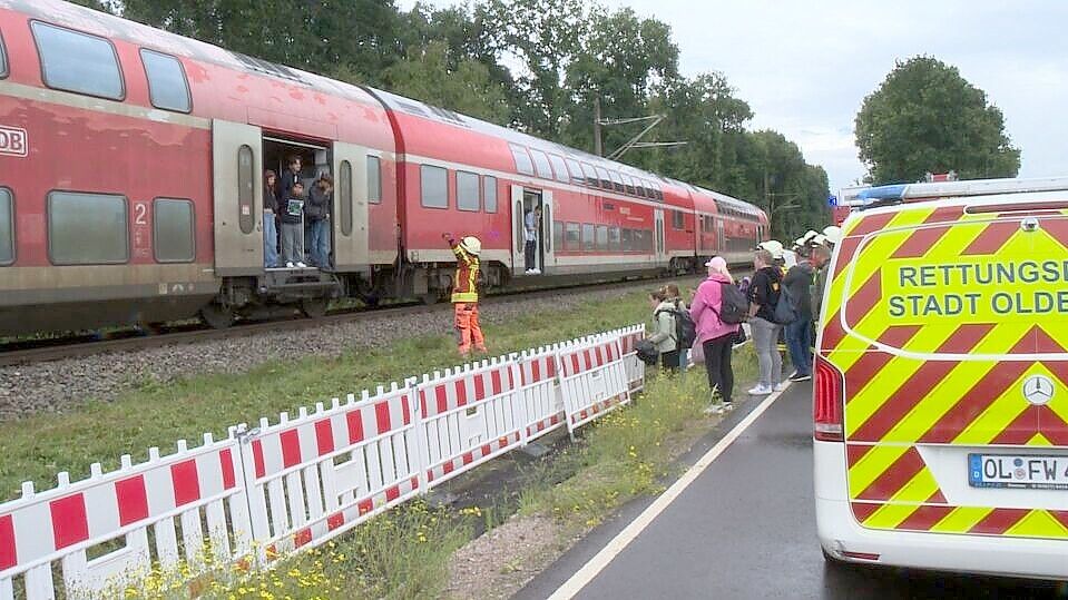 Einsatzkräfte der Feuerwehr evakuierten die 242 Fahrgäste aus dem Regionalexpress. Der Zug blieb nach dem Zusammenstoß mit einem Auto auf dem Bahnübergang Kayhauserfeld in freier Landschaft stehen. Foto: Nonstopnews